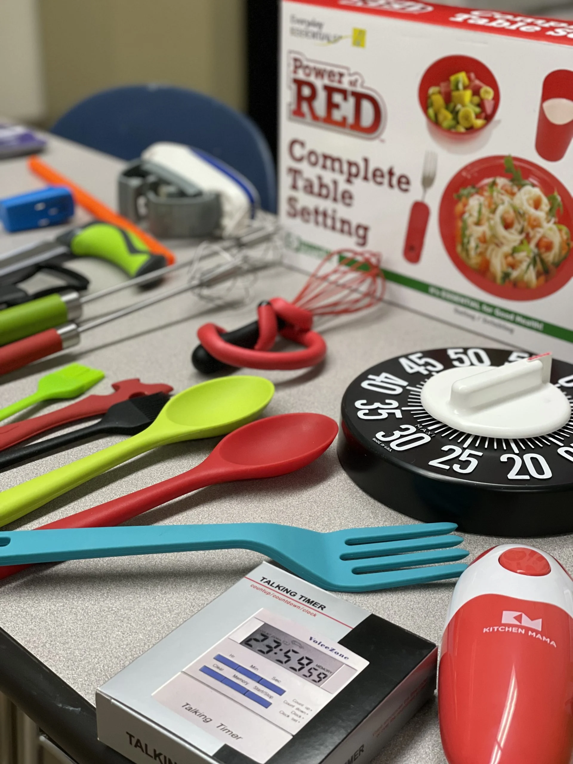 A variety of adaptive tools including no slip utensils talking timers adapted grips and a tactile timer scaled 1