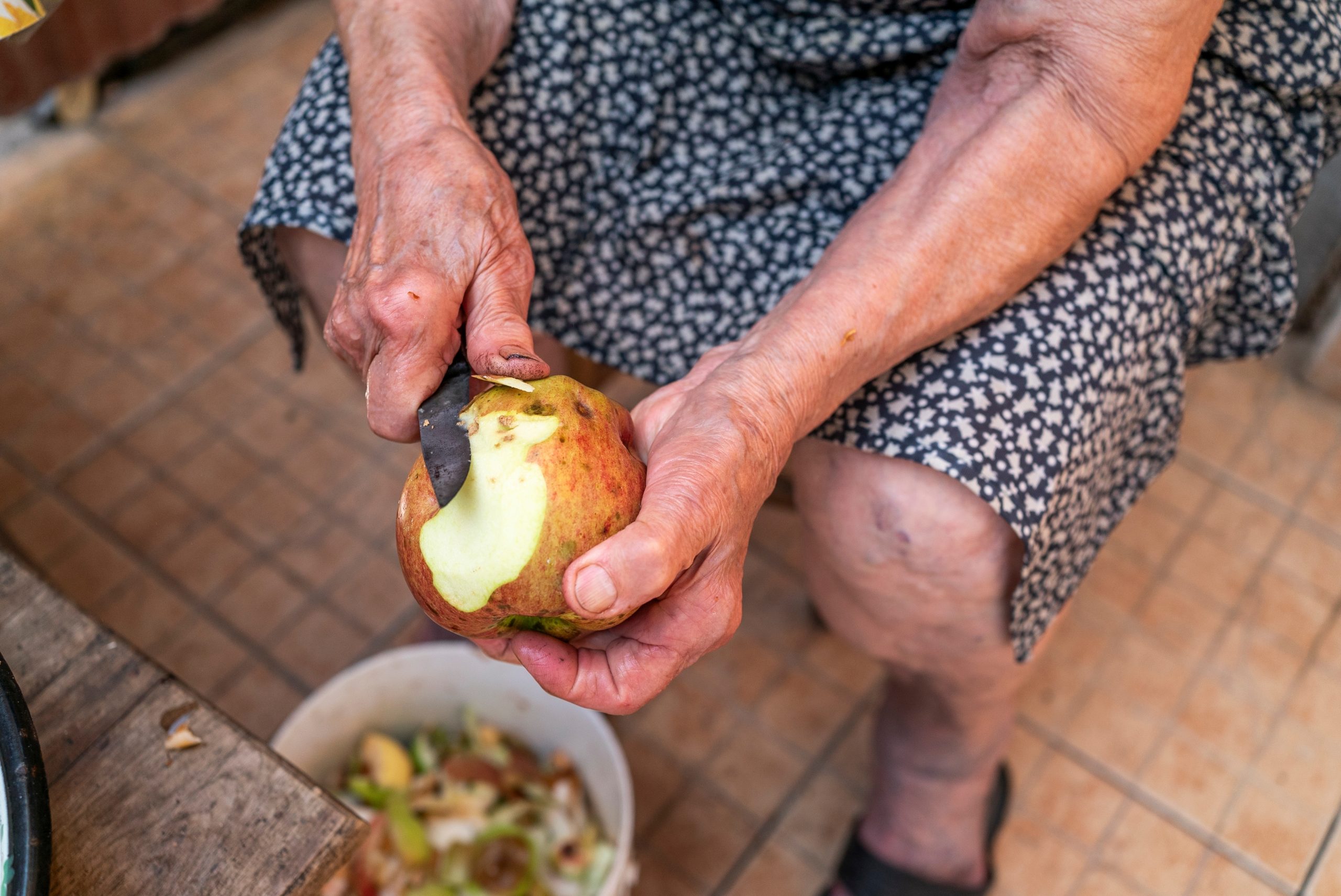 arthritic hands peeling an apple