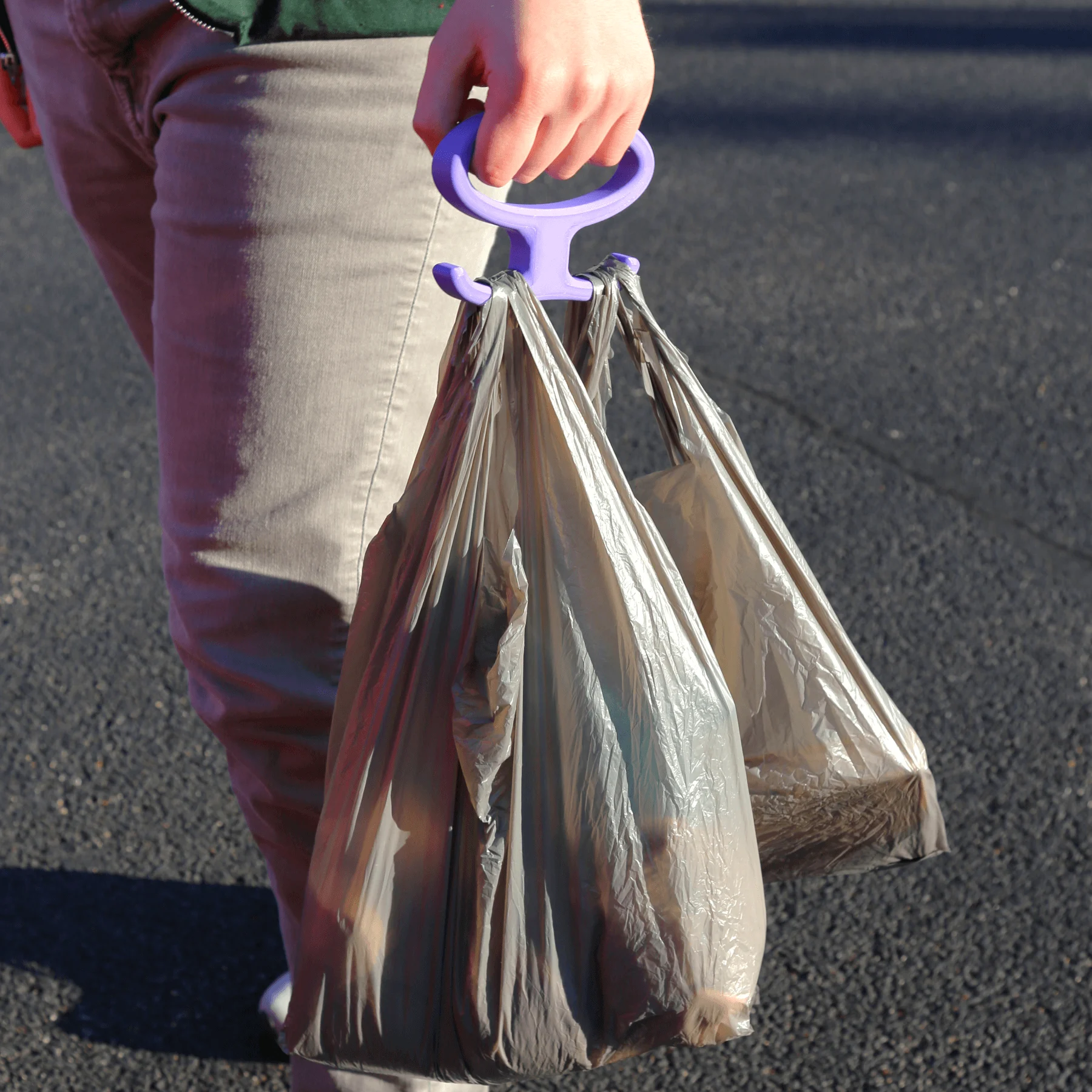 Person Holding a Doubledsided Plastic Bag Carrier